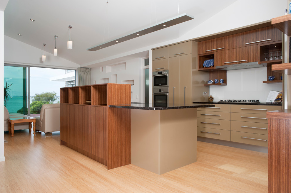 Photo of a large contemporary l-shaped eat-in kitchen in Other with a double-bowl sink, flat-panel cabinets, brown cabinets, granite benchtops, white splashback, glass sheet splashback, stainless steel appliances, bamboo floors and with island.