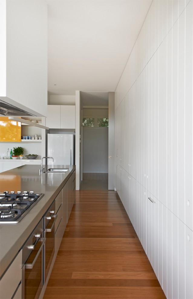 This is an example of a contemporary kitchen in Melbourne with white cabinets and with island.