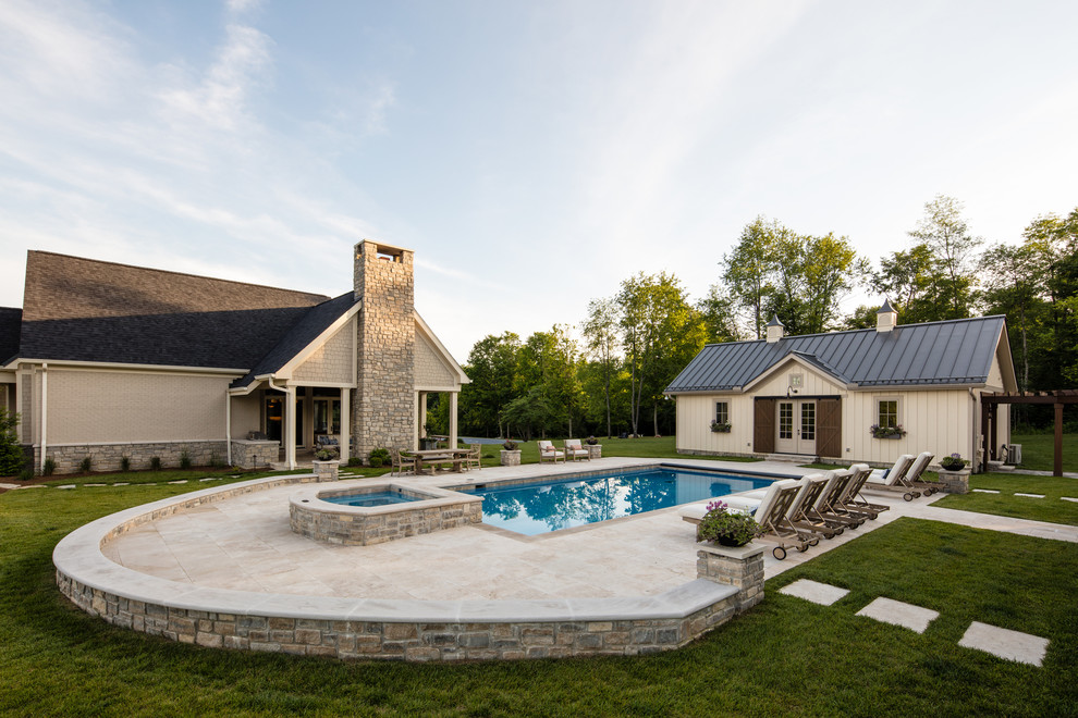 This is an example of a country backyard rectangular lap pool in Cincinnati with natural stone pavers.