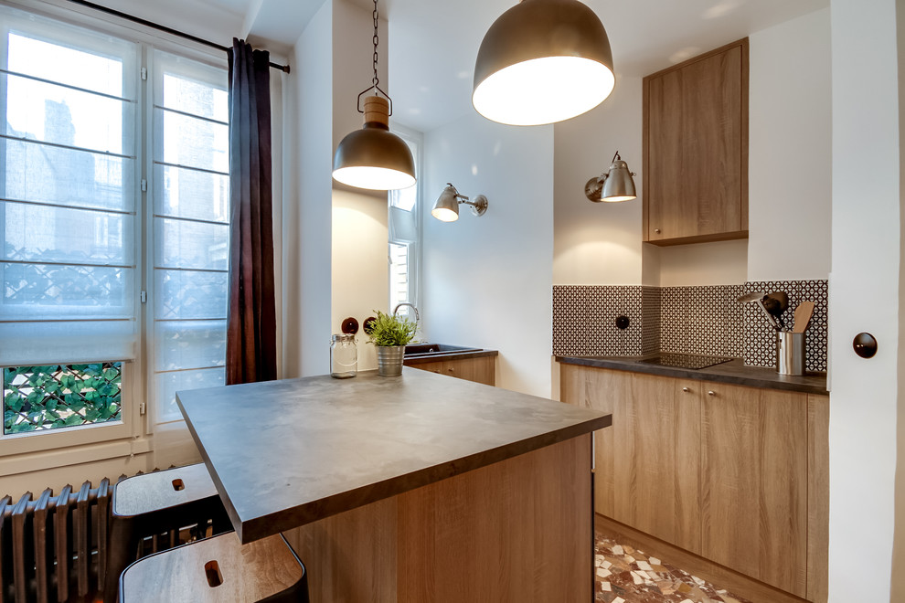 This is an example of a small industrial u-shaped open plan kitchen in Paris with a single-bowl sink, flat-panel cabinets, light wood cabinets, concrete benchtops, black splashback, ceramic splashback, stainless steel appliances, terrazzo floors and with island.