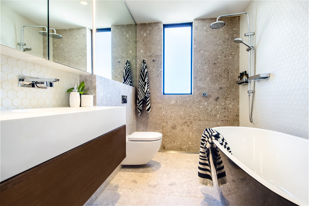 Design ideas for a mid-sized contemporary bathroom in Sydney with white cabinets, a freestanding tub, an open shower, a wall-mount toilet, porcelain tile, porcelain floors, solid surface benchtops and white benchtops.