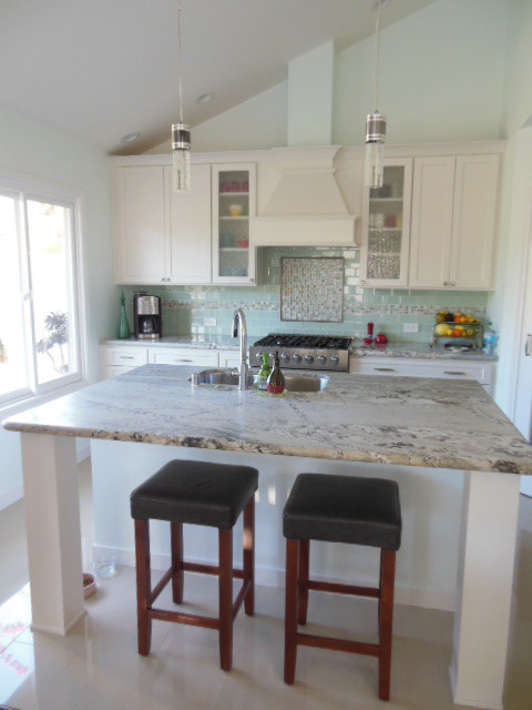 Eat-in kitchen - mid-sized transitional l-shaped porcelain tile and white floor eat-in kitchen idea in San Diego with an undermount sink, shaker cabinets, white cabinets, quartz countertops, green backsplash, subway tile backsplash, stainless steel appliances and an island