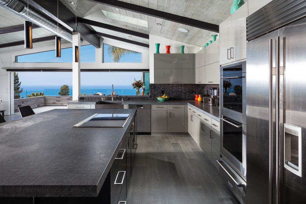 Design ideas for a large contemporary l-shaped open plan kitchen in Orange County with flat-panel cabinets, grey cabinets, with island, black benchtop, a farmhouse sink, grey splashback, stainless steel appliances, grey floor, mosaic tile splashback and dark hardwood floors.