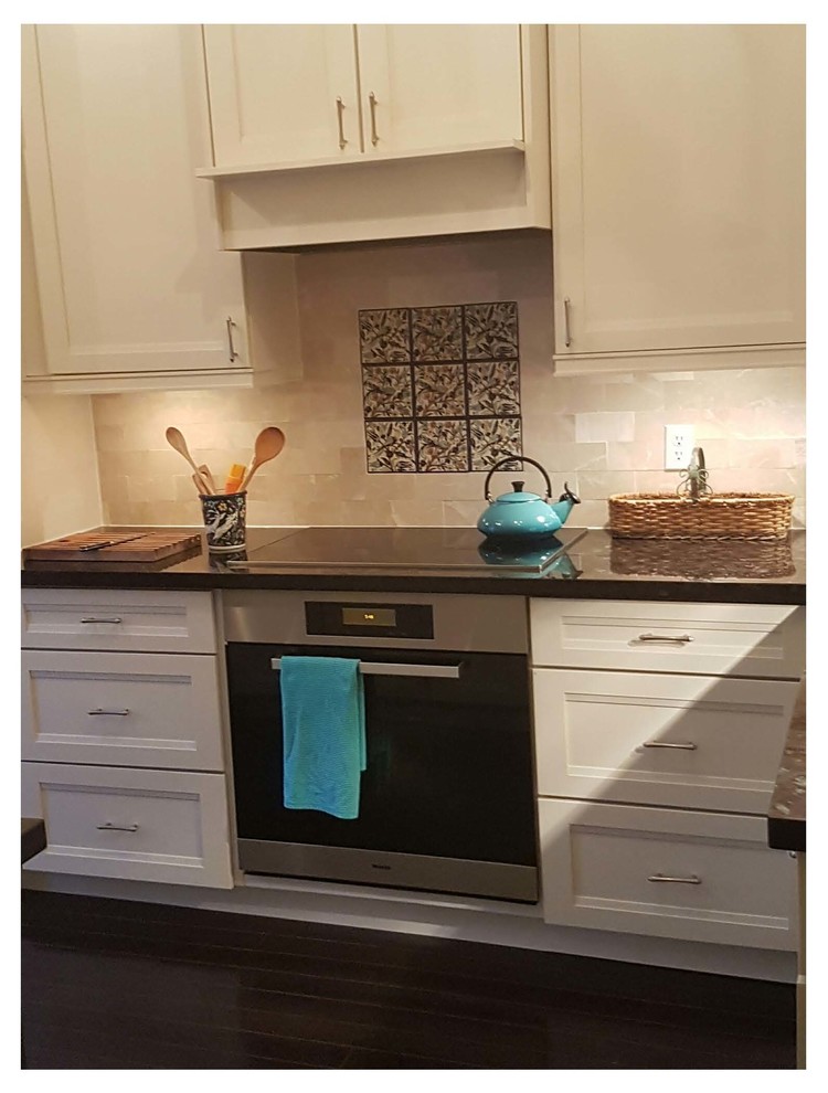 Mid-sized transitional u-shaped dark wood floor eat-in kitchen photo in Toronto with an undermount sink, recessed-panel cabinets, white cabinets, granite countertops, beige backsplash, stone tile backsplash, stainless steel appliances and a peninsula