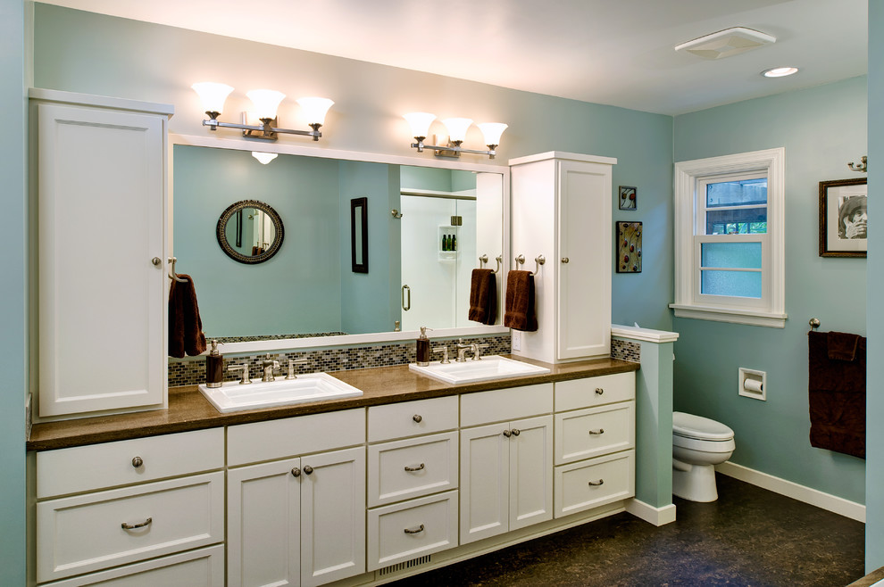 Traditional bathroom in Other with recessed-panel cabinets, white cabinets and brown tile.