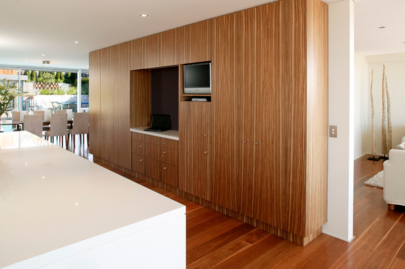 This is an example of a mid-sized contemporary single-wall eat-in kitchen in Sydney with a drop-in sink, flat-panel cabinets, stainless steel appliances, medium hardwood floors, with island, white cabinets, quartz benchtops, white splashback and marble splashback.