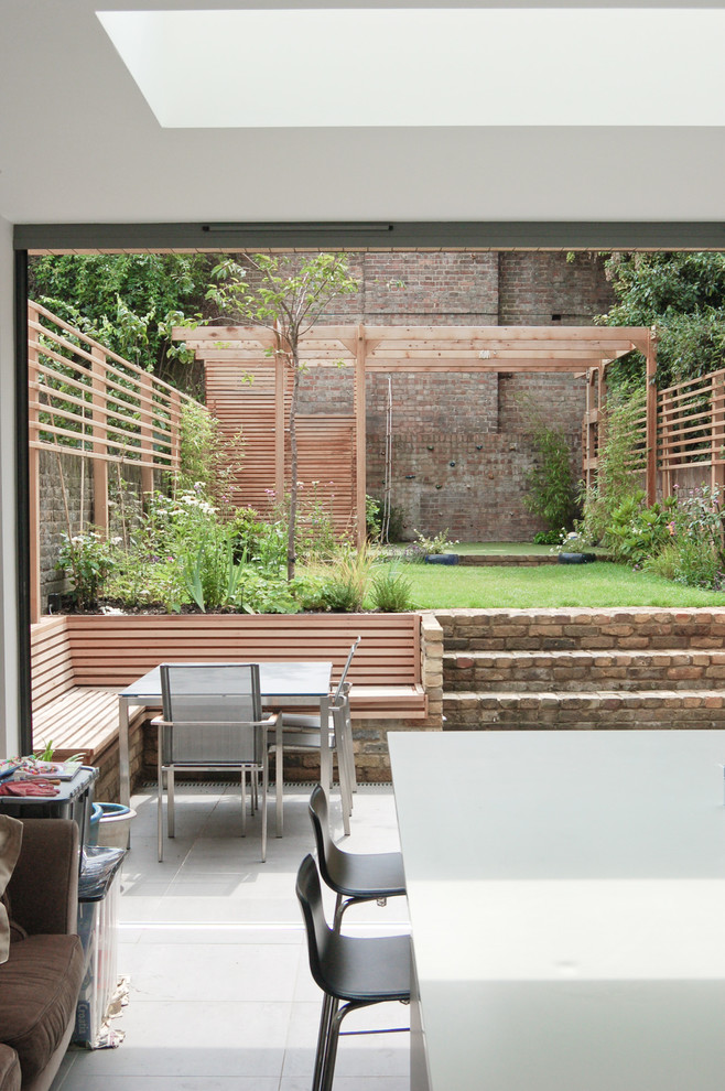 Design ideas for a mid-sized contemporary backyard patio in London.
