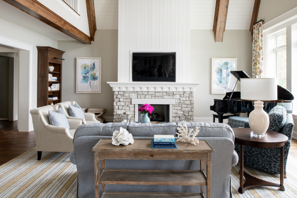 Example of a large beach style formal and open concept medium tone wood floor, brown floor and shiplap ceiling living room design in Minneapolis with gray walls, a standard fireplace, a stone fireplace and a wall-mounted tv