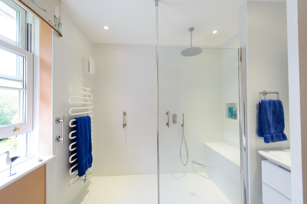 This is an example of a medium sized modern shower room bathroom in Kent with a wall-mounted sink, flat-panel cabinets, white cabinets, an alcove shower, a wall mounted toilet, white tiles, ceramic tiles and red walls.
