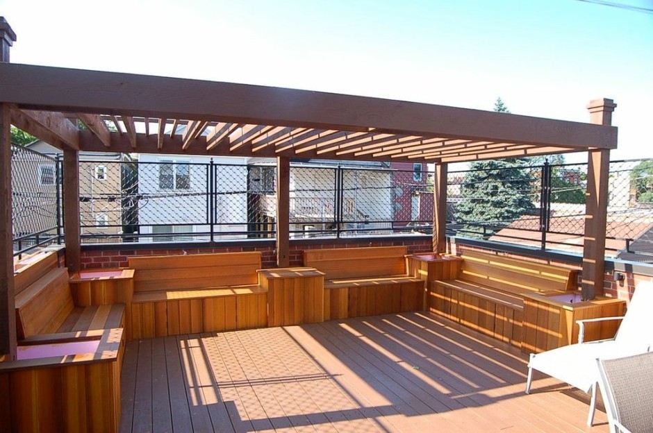 This is an example of a large transitional rooftop deck in Chicago with a pergola.