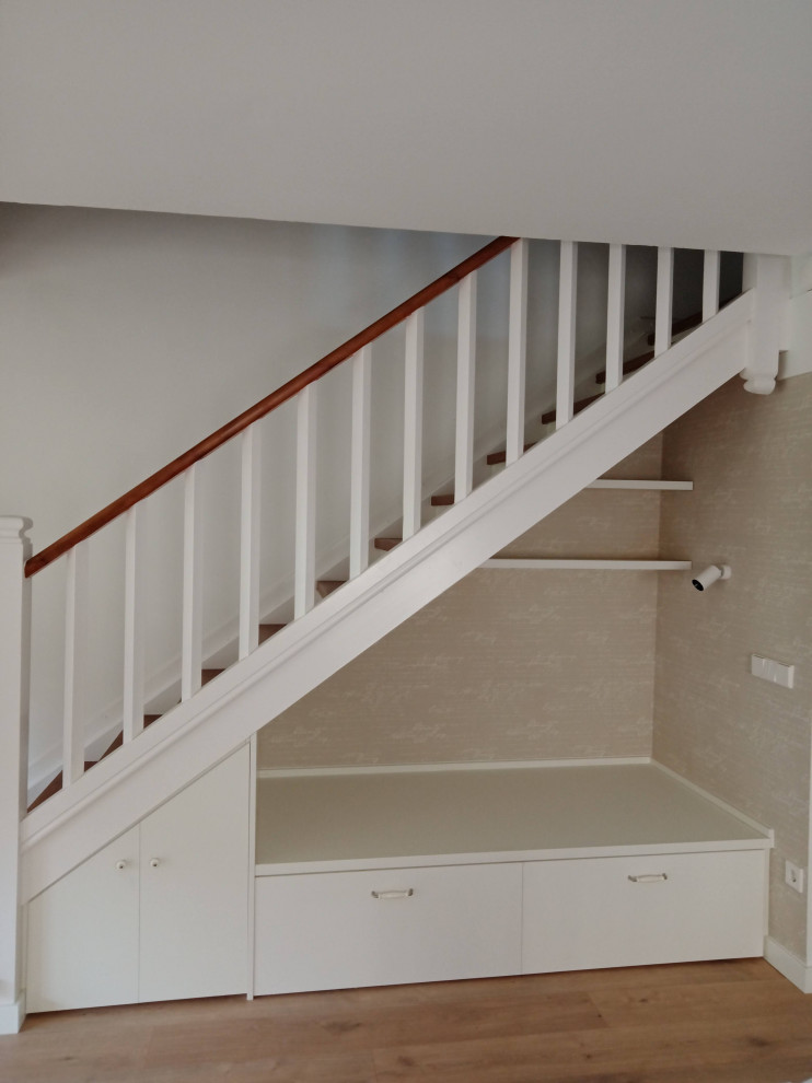 Cette photo montre un escalier peint chic en L de taille moyenne avec des marches en bois, un garde-corps en bois et du papier peint.