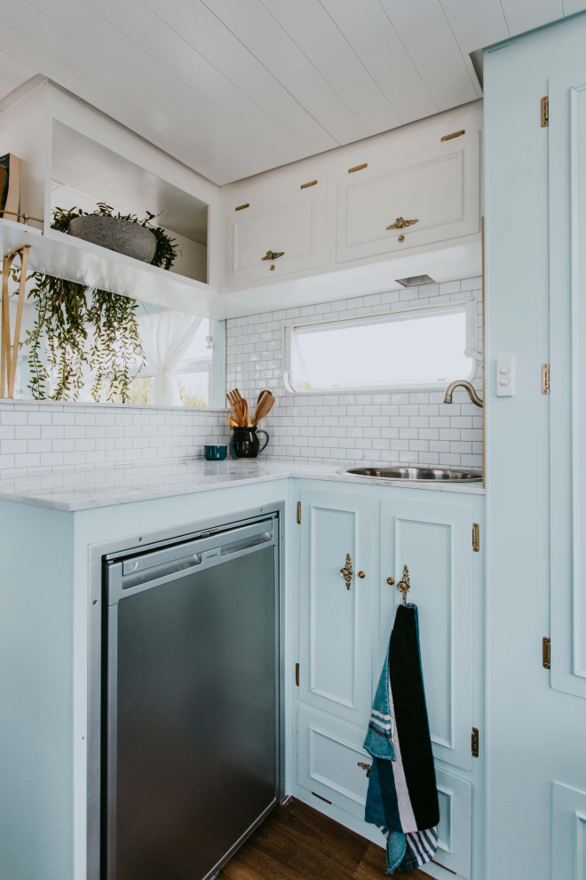 Beach style kitchen in Gold Coast - Tweed with a drop-in sink, blue cabinets, laminate benchtops, white splashback, subway tile splashback, stainless steel appliances and vinyl floors.