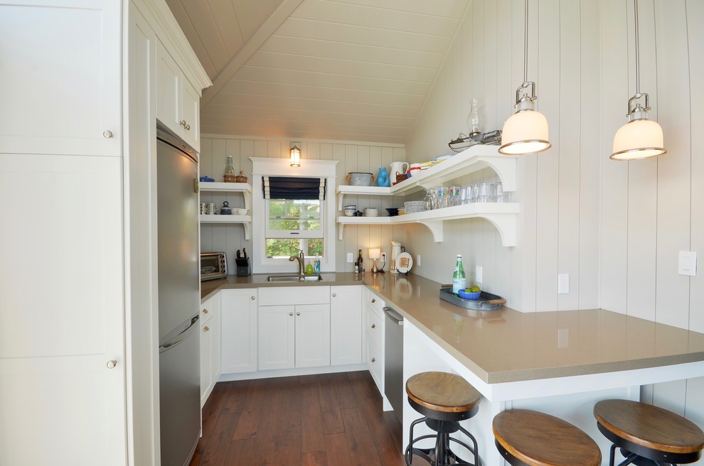 This is an example of a small beach style u-shaped separate kitchen in Toronto with an undermount sink, open cabinets, white cabinets, stainless steel appliances, medium hardwood floors, orange floor, solid surface benchtops, white splashback, timber splashback and no island.