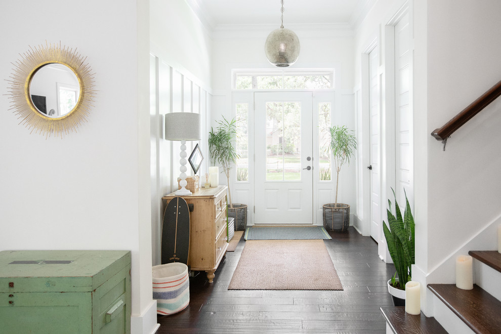 Inspiration for a beach style foyer in Charleston with white walls, dark hardwood floors, a single front door, a white front door and brown floor.