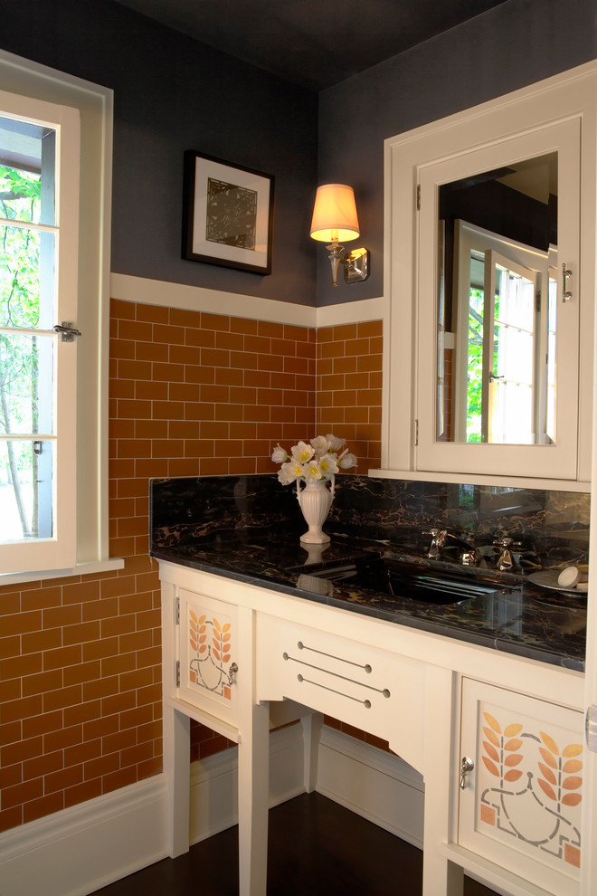 Inspiration for an arts and crafts powder room in Minneapolis with furniture-like cabinets, white cabinets, brown tile, subway tile, an undermount sink and black walls.