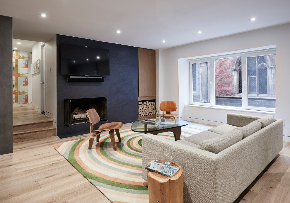 Foto di un soggiorno minimal con pareti bianche, parquet chiaro, camino classico, TV a parete e pavimento beige