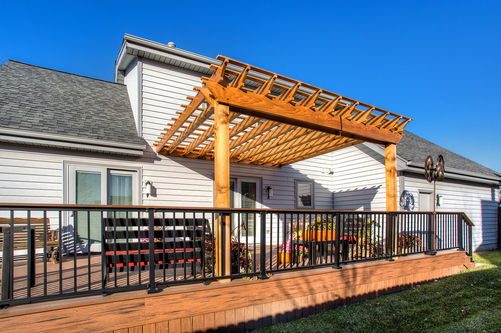 Example of a mid-sized transitional backyard deck design with a pergola