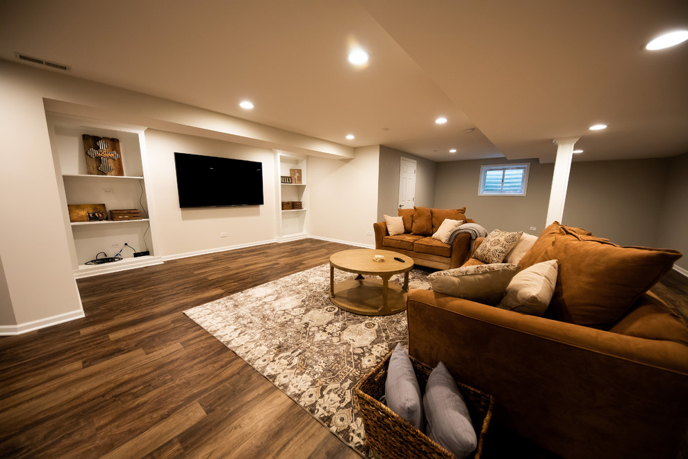 Expansive traditional look-out basement in Chicago with beige walls, dark hardwood floors, no fireplace and beige floor.