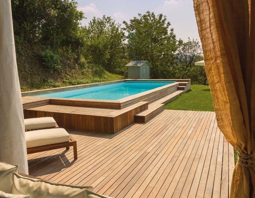 Photo of a mid-sized mediterranean front yard rectangular aboveground pool in Other with decking.