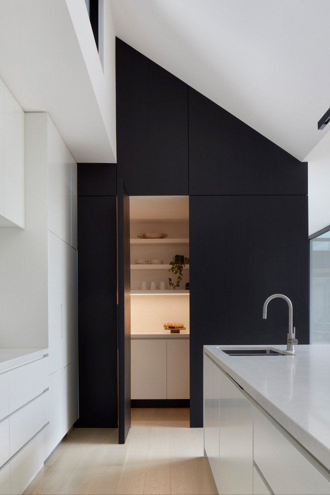 Inspiration för ett funkis kök med öppen planlösning, med en undermonterad diskho, vita skåp, bänkskiva i kvarts, en köksö och beiget golv
