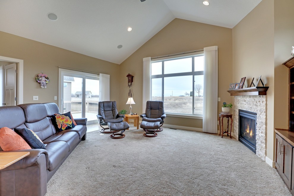 Photo of a mid-sized traditional open concept living room in Minneapolis with beige walls, carpet, a standard fireplace, a stone fireplace surround and a built-in media wall.