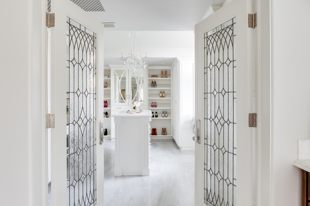 Large traditional women's walk-in wardrobe in Sacramento with recessed-panel cabinets, white cabinets, marble floors, white floor and exposed beam.