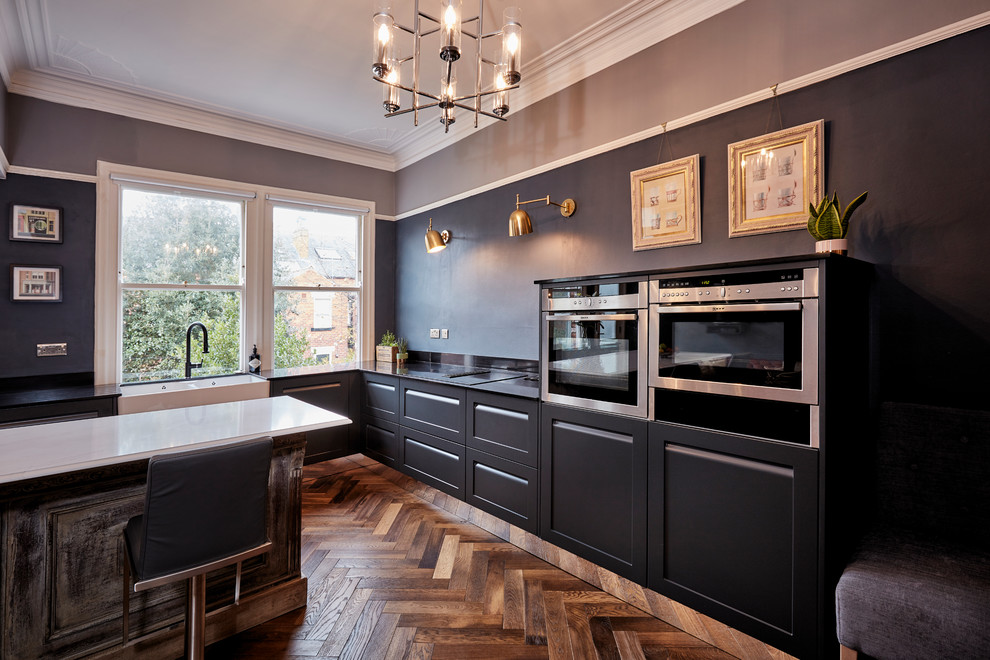 Mid-sized transitional l-shaped open plan kitchen in Other with shaker cabinets, grey cabinets, quartzite benchtops, black splashback, with island and multi-coloured benchtop.