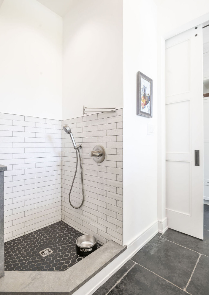 This is an example of a modern bathroom in Baltimore with shaker cabinets, white cabinets, white walls and black floors.