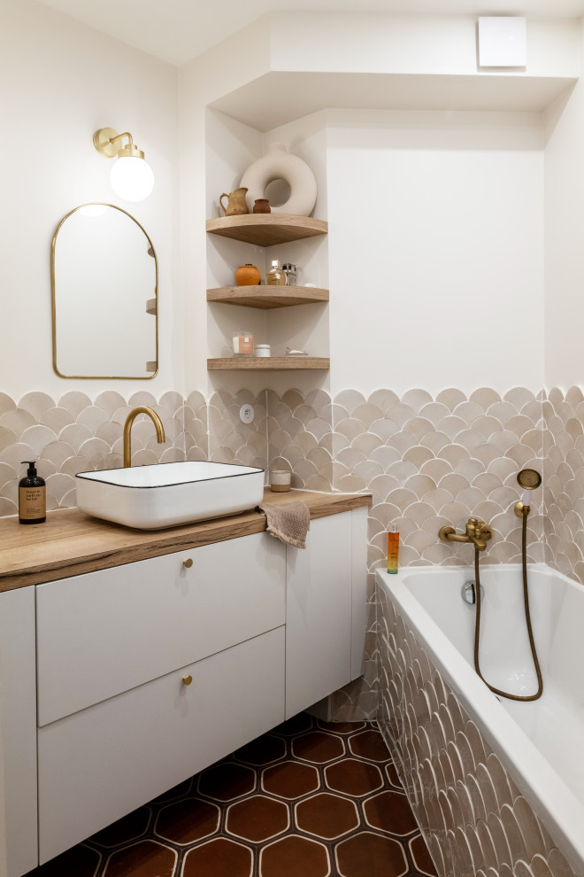 Inspiration for a small scandinavian ensuite bathroom in Paris with beaded cabinets, beige cabinets, a submerged bath, a corner shower, beige tiles, terracotta tiles, white walls, cement flooring, a console sink, wooden worktops, brown floors, a hinged door, brown worktops, a single sink and a floating vanity unit.