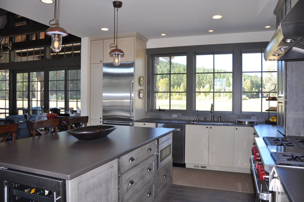 Inspiration for a large rustic l-shaped medium tone wood floor eat-in kitchen remodel in Seattle with an undermount sink, shaker cabinets, distressed cabinets, quartz countertops, gray backsplash, stone tile backsplash, stainless steel appliances and an island
