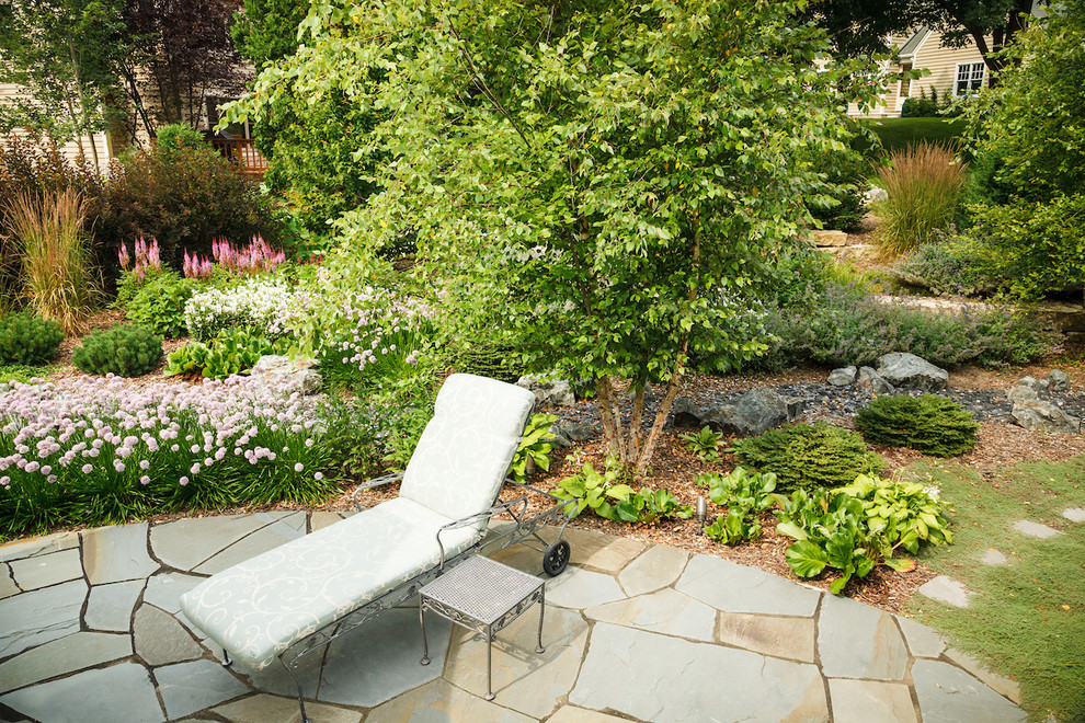 Photo of a mid-sized arts and crafts backyard patio in Milwaukee with natural stone pavers.
