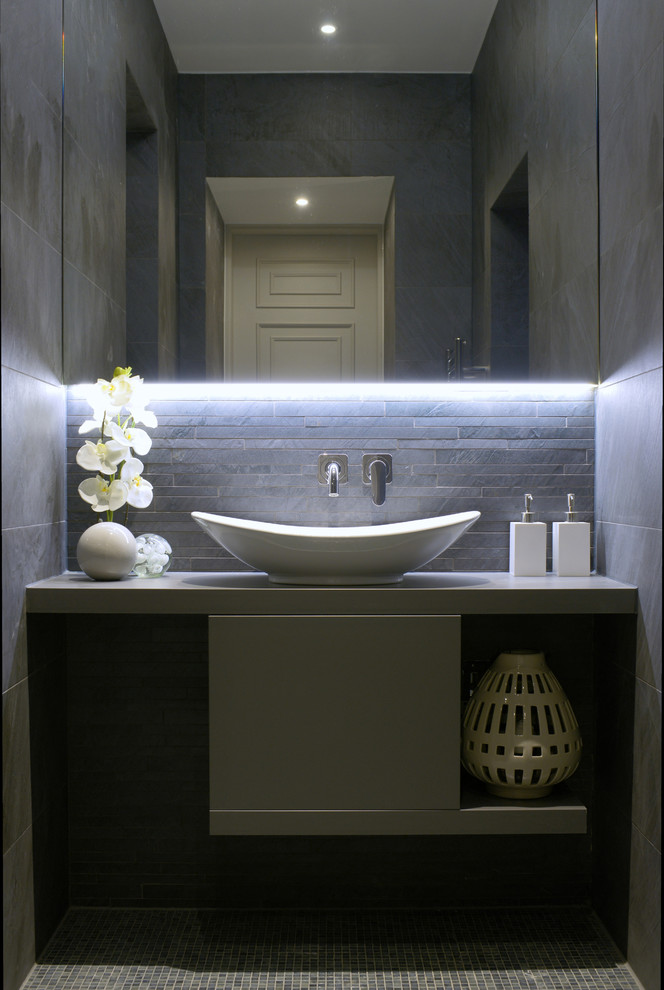 Photo of a mid-sized contemporary bathroom in Gloucestershire with flat-panel cabinets, grey cabinets, an open shower, gray tile, porcelain tile, grey walls, mosaic tile floors, with a sauna, a vessel sink and laminate benchtops.