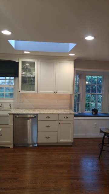 This is an example of a small traditional eat-in kitchen in Baltimore with recessed-panel cabinets, white cabinets, multi-coloured splashback, ceramic splashback, stainless steel appliances, medium hardwood floors and brown floor.