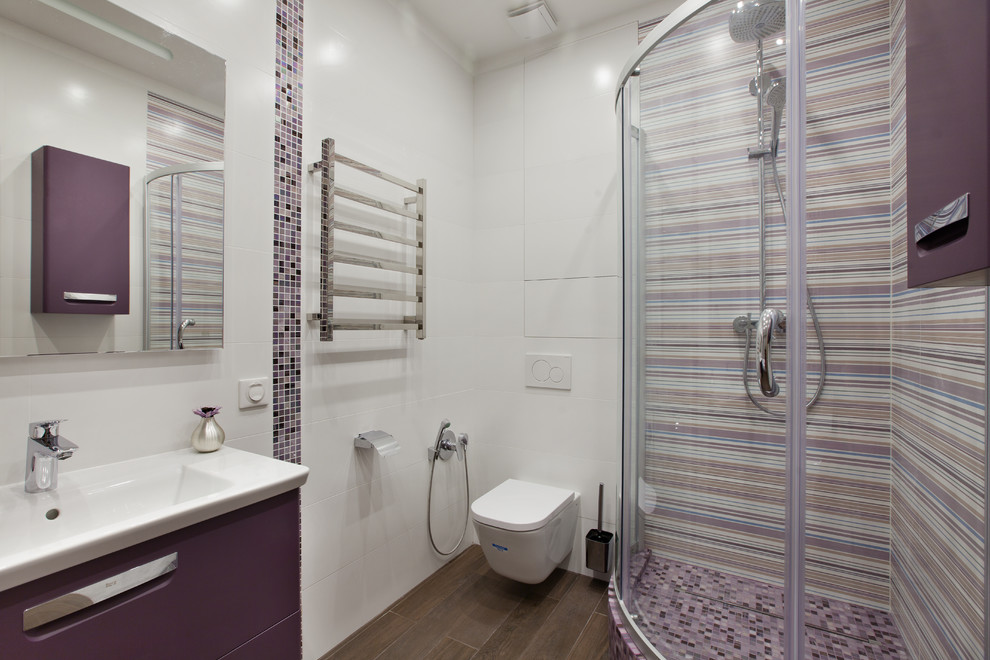 Пример оригинального дизайна: ванная комната среднего размера с плоскими фасадами, фиолетовыми фасадами, отдельно стоящей ванной, угловым душем, белой плиткой, керамогранитной плиткой, белыми стенами, полом из керамогранита, душевой кабиной, подвесной раковиной, столешницей из искусственного камня, коричневым полом и душем с раздвижными дверями