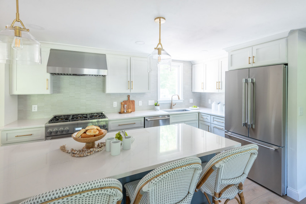 Eat-in kitchen - mid-sized transitional l-shaped light wood floor and brown floor eat-in kitchen idea in Boston with an undermount sink, shaker cabinets, white cabinets, quartz countertops, gray backsplash, ceramic backsplash, stainless steel appliances, an island and white countertops