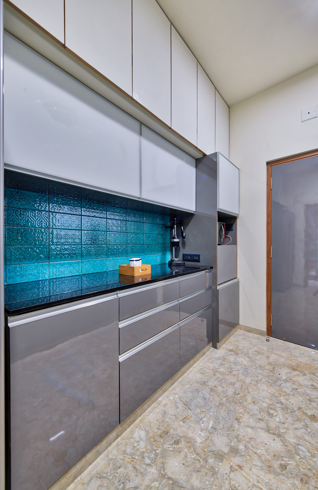 Contemporary kitchen in Ahmedabad With Flat-panel Cabinets, Grey Cabinets, Blue Splashback and Ceramic Splashback.