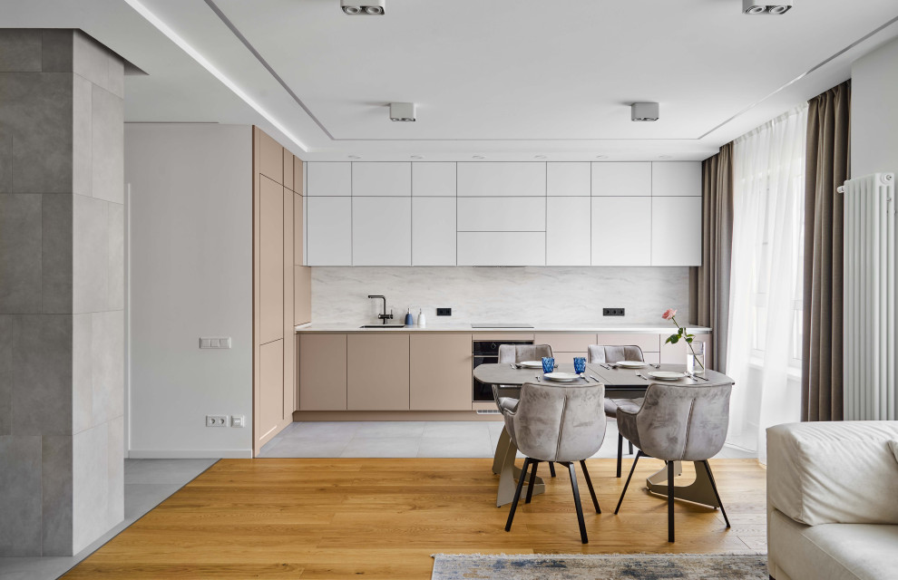 Mid-sized contemporary l-shaped eat-in kitchen in Saint Petersburg with an undermount sink, flat-panel cabinets, solid surface benchtops, porcelain floors, no island and grey floor.