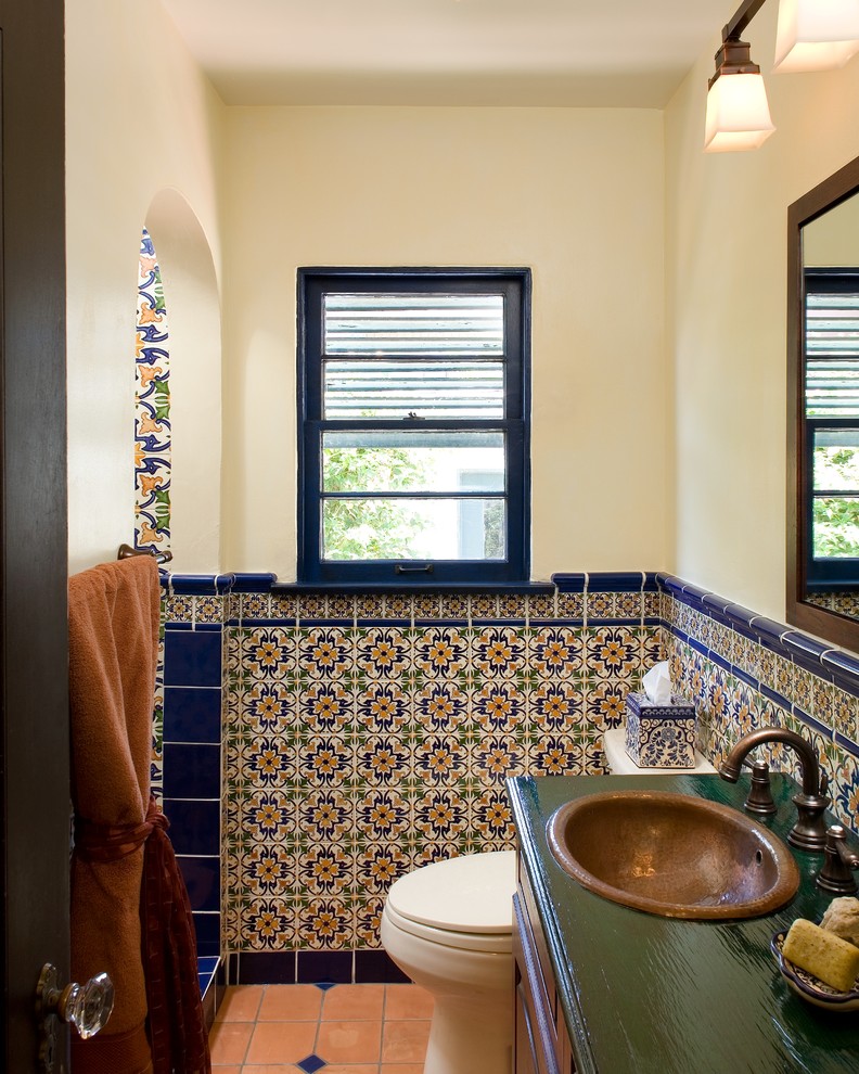 Design ideas for a mediterranean bathroom in San Diego with ceramic tile, a drop-in sink, wood benchtops, multi-coloured tile and terra-cotta floors.