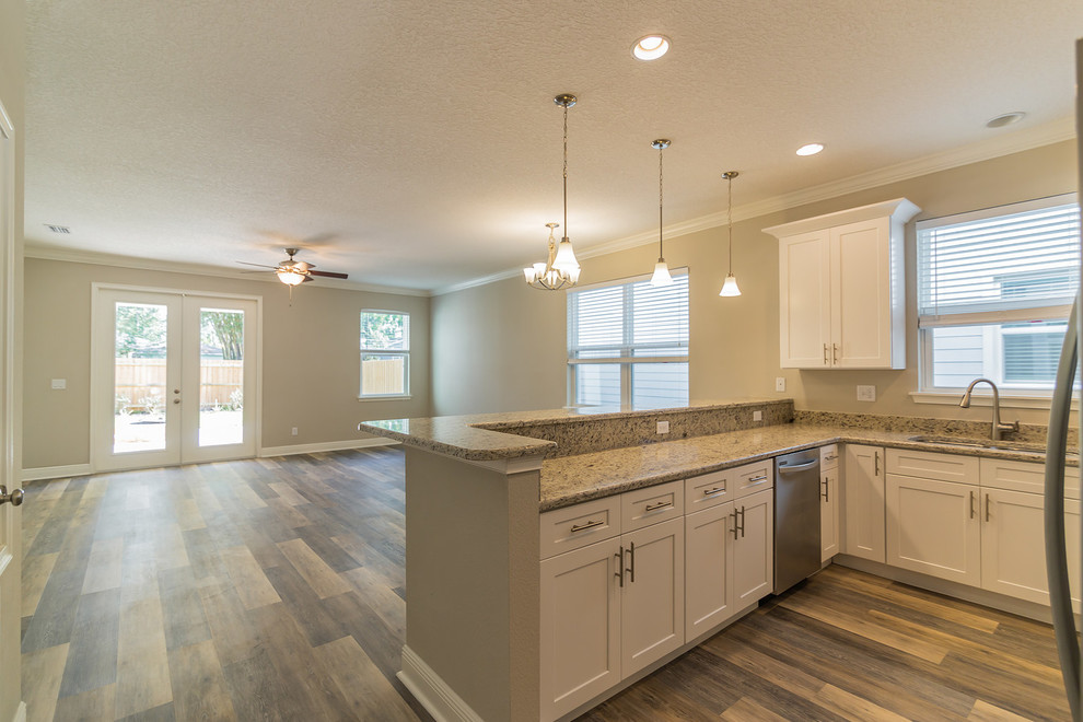 Large transitional u-shaped eat-in kitchen in Orlando with shaker cabinets, white cabinets, granite benchtops, stainless steel appliances, laminate floors and grey floor.