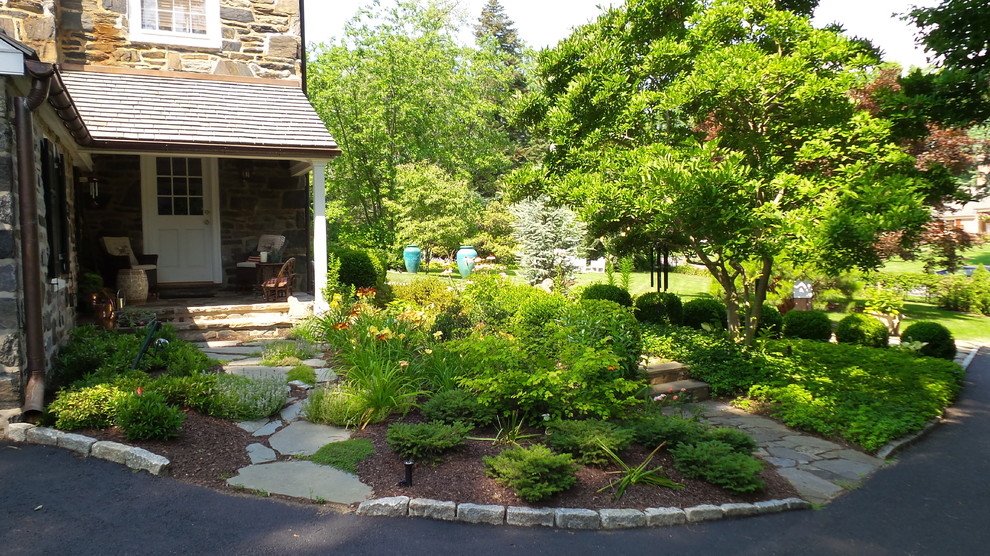This is an example of a traditional backyard garden for summer in Philadelphia with natural stone pavers.