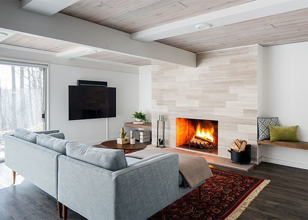 Large midcentury family room in Bridgeport with white walls, a standard fireplace, a concrete fireplace surround, a wall-mounted tv and brown floor.
