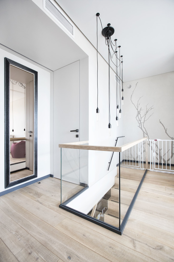 Contemporary hallway in Moscow with white walls, light hardwood floors and beige floor.