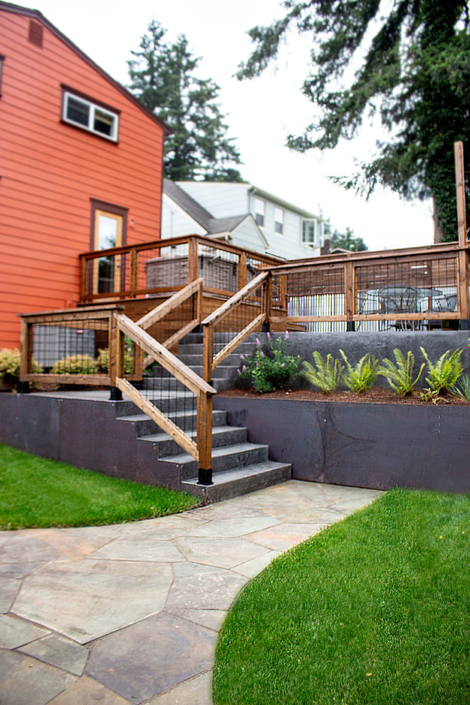 This is an example of a mid-sized modern backyard full sun garden in Portland with natural stone pavers.