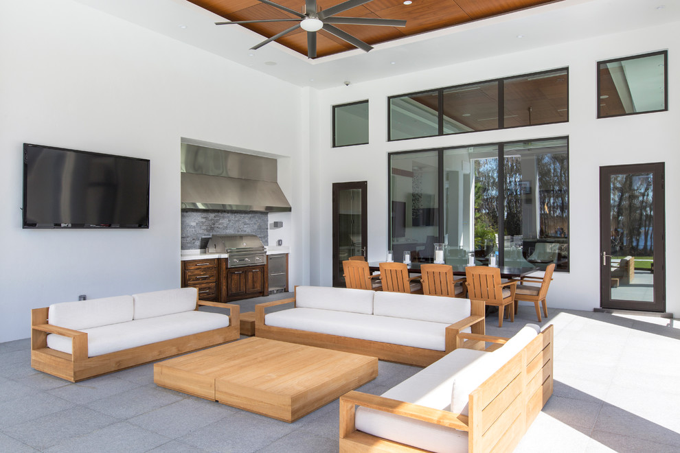 Large contemporary backyard patio in Orlando with an outdoor kitchen and a roof extension.