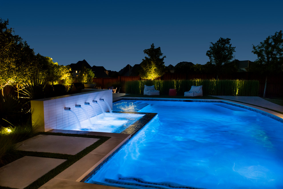 Eclectic backyard custom-shaped lap pool in Dallas with a water feature and concrete pavers.