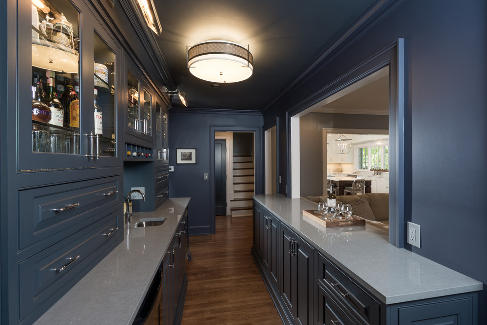 Inspiration for a mid-sized transitional galley wet bar in Columbus with an undermount sink, beaded inset cabinets, blue cabinets, quartz benchtops, mirror splashback and medium hardwood floors.