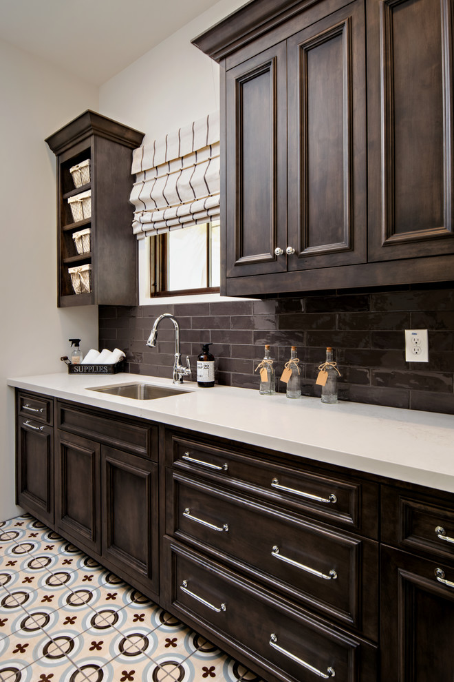 Design ideas for a traditional single-wall wet bar in Phoenix with an undermount sink, recessed-panel cabinets, dark wood cabinets, brown splashback, subway tile splashback and multi-coloured floor.