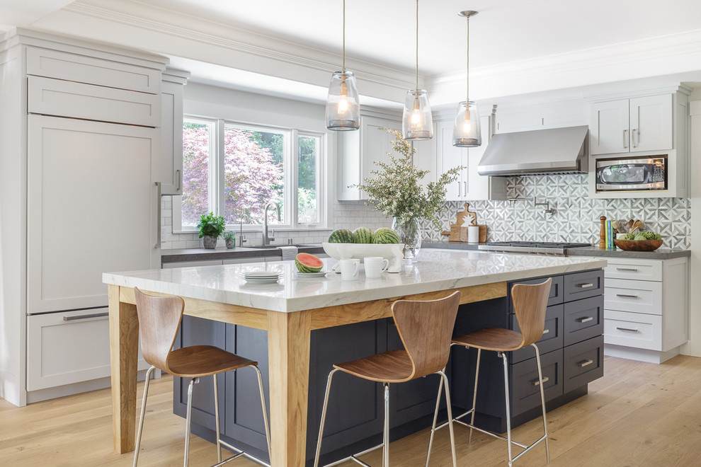 Large transitional l-shaped open plan kitchen in San Francisco with shaker cabinets, white cabinets, grey splashback, panelled appliances, with island, a single-bowl sink, light hardwood floors, marble benchtops, marble splashback, beige floor and white benchtop.