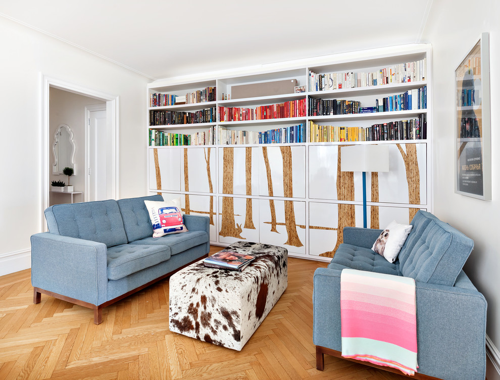 This is an example of a small contemporary family room in New York with a library, white walls, medium hardwood floors and brown floor.