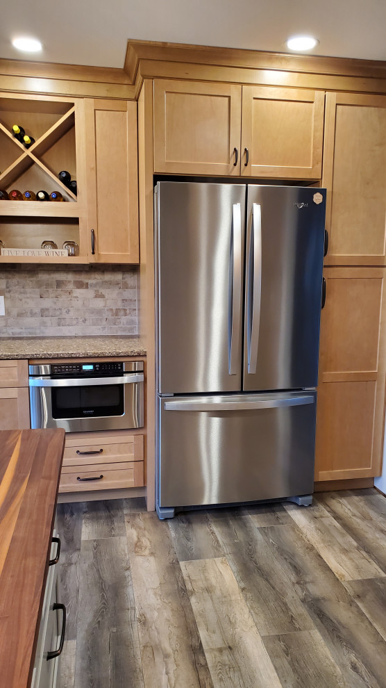 Mid-sized mountain style u-shaped vinyl floor and gray floor enclosed kitchen photo with shaker cabinets, light wood cabinets, quartz countertops, an island, multicolored countertops, an undermount sink, beige backsplash, stone tile backsplash and stainless steel appliances